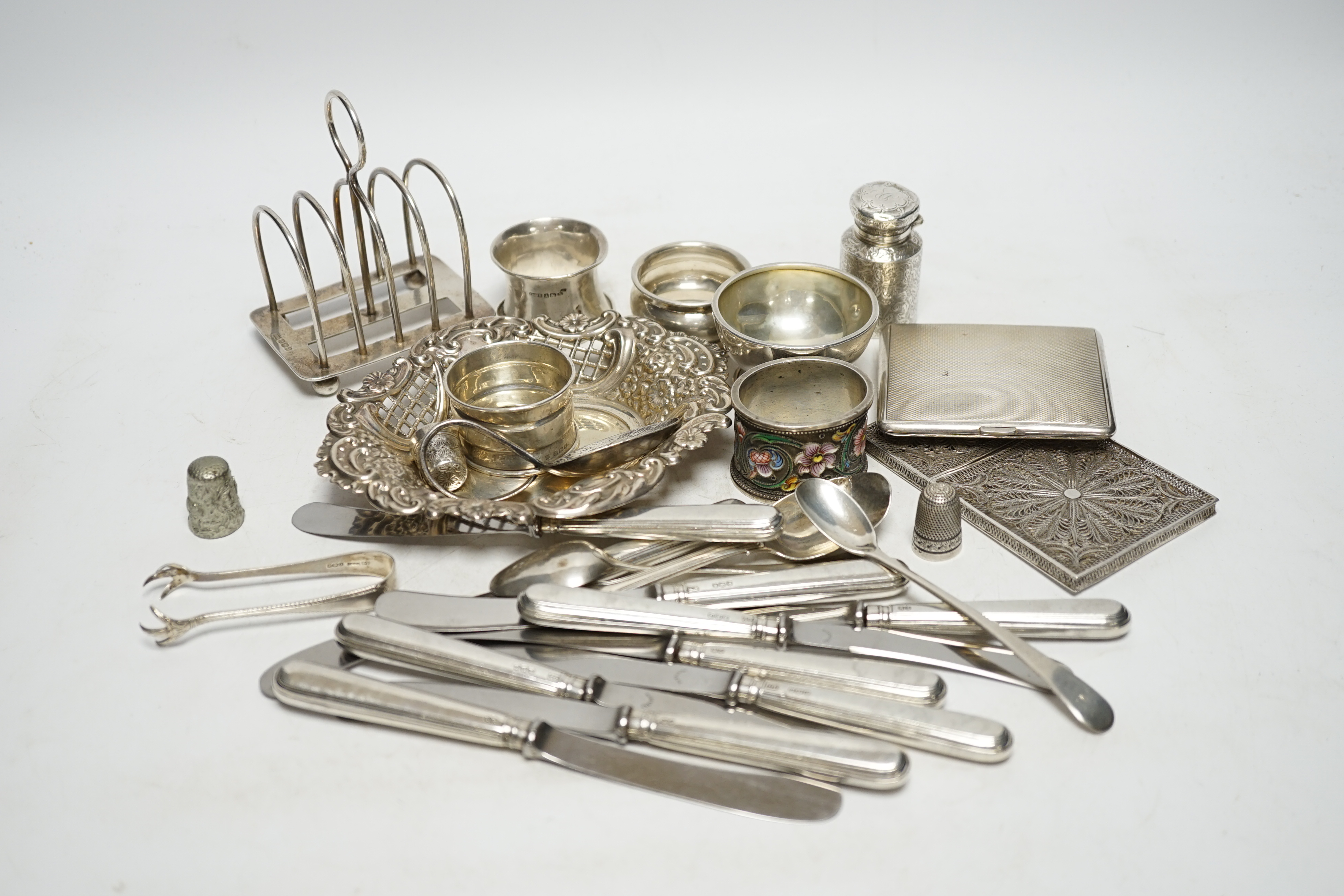 A quantity of assorted silver ad white metal items including a Russian 84 zolotnik and cloisonné enamel napkin ring, bon bon dish, scent bottle, cutlery, toast rack, cigarette case etc. Condition - fair to poor